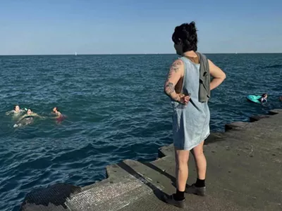 Annelise Rittberg watches as their four friends enjoy a late summer dip in Lake Michigan just south of Belmont Harbor.