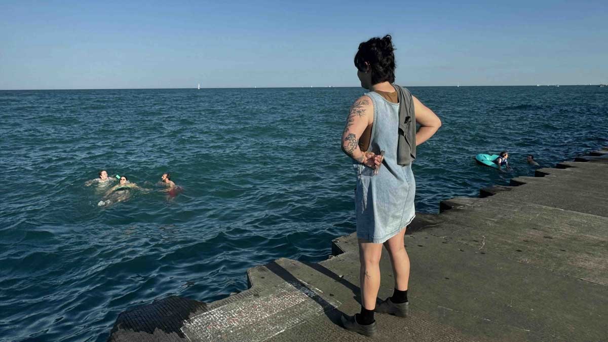 Annelise Rittberg watches as their four friends enjoy a late summer dip in Lake Michigan just south of Belmont Harbor.