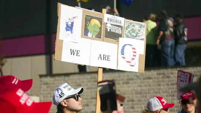 A protester holds a sign referencing the QAnon conspiracy theory at a rally for President Donald Trump in Detroit.