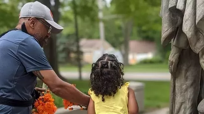 Plaintiff Tony Miller with his daughter at a statue in the Garden of Honor in Allendale Township, where he wanted to inscribe a brick with the phrase "Black Lives Matter” or “Indigenous Lives Matter.”