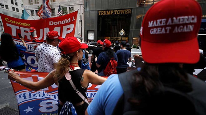 Supporters of former President Donald Trump’s gather with flags in front of his Fifth Avenue residence on July 14, 2024 in New York City.