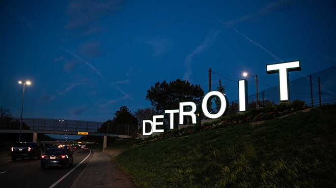 The large Detroit sign illuminated at night.