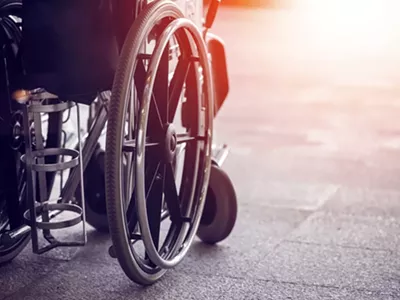 A local activist in a wheelchair has filed suit against a municipal lawyer over demeaning emails.