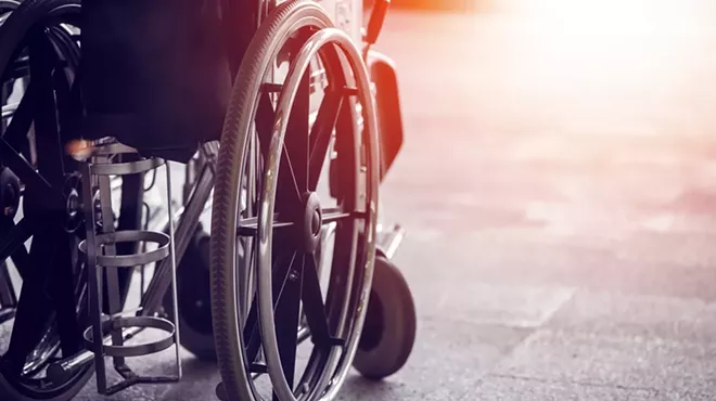 A local activist in a wheelchair has filed suit against a municipal lawyer over demeaning emails.