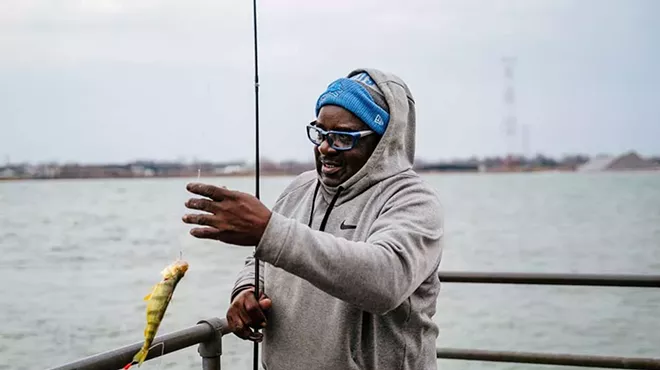 Ivan Bentley unhooks a caught fish and drops it into a bucket at Delray Park.