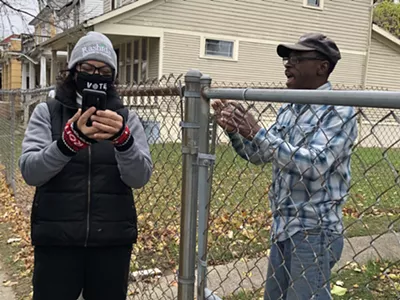 Rashida Tlaib helps one of her constituents navigate the unemployment system while knocking on doors on Sunday.