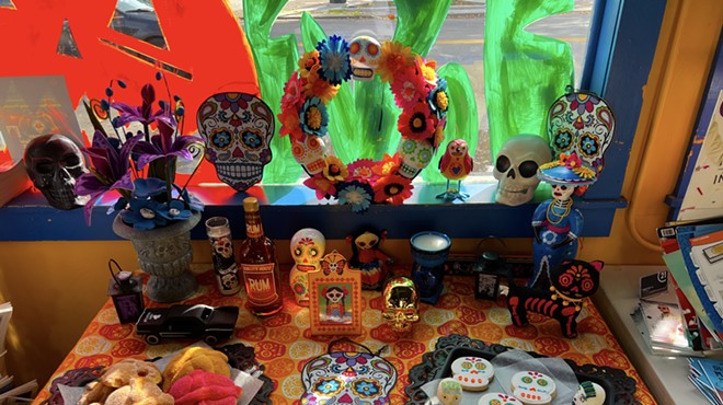An ofrenda is an altar decorated with offerings to the dead like marigolds, food, photos of the deceased, sugar skulls, and Pan de Muerto (day of the dead bread).