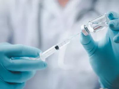 A doctor filling a syringe with a vaccine.