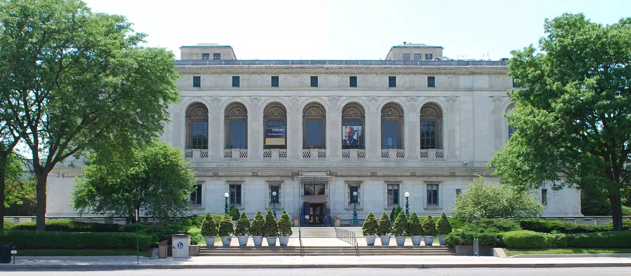 Museum Gala Bruce Wayne and Diana Price banter over antiquities in the main branch of the Detroit Public Library, which dressed up as an art gallery for its appearance in the movie. (Photo Credit: Andrew Jameson via Wikimedia Commons)