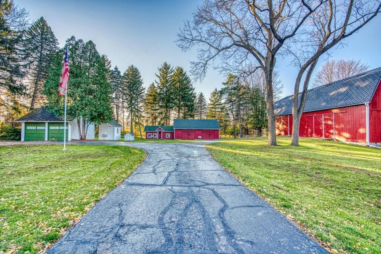 This historic Mid-Century Modern farmhouse in Okemos includes a barn and carriage house