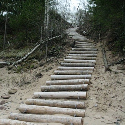 This rough stair of logs ascends to the Au Sable Point Light. Atop the stairs, a building had a defib kit!
