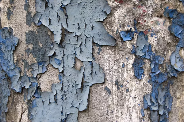 Paint peeling from an old home. - shutterstock