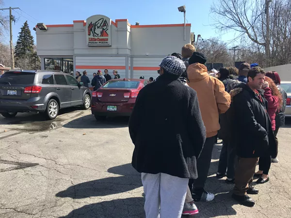 A line snakes around the parking lot of the Little Caesars in Ferndale ahead of Monday's free lunch combo promo. - Miriam Marini