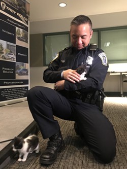 OFFICER JULIAN WITH A POTENTIAL CAT CANDIDATE.