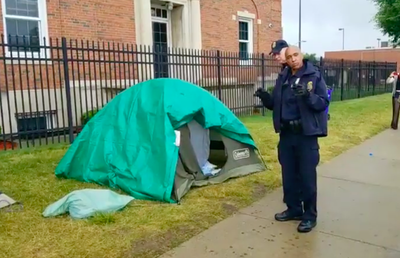 An officer with Homeland Security’s Federal Protective Services Police prepares to take down the remaining tents in Detroit's Occupy ICE encampment. - Metro Detroit Political Action Network