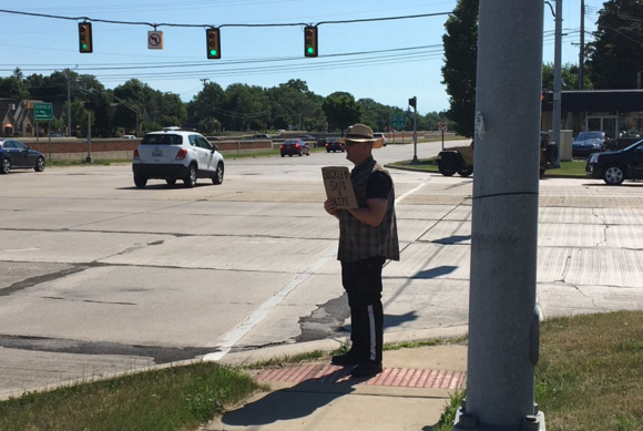 An MSP trooper poses as what very much resembles a panhandler at the intersection of Southfield Road and I-696 on Tuesday. - Twitter, @mspmetrodetroit