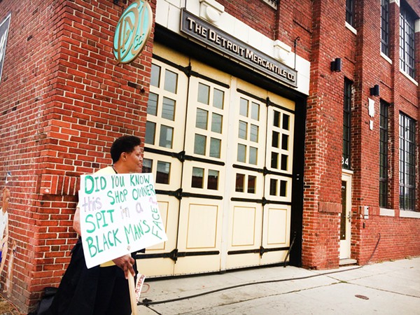 A protester outside Detroit Mercantile on Saturday. - TOM PERKINS