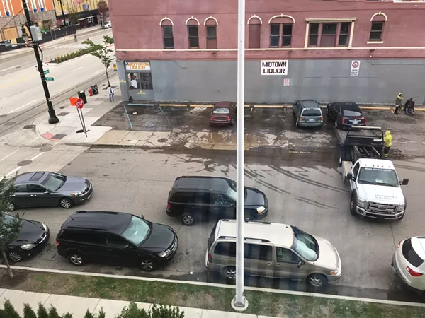 A Breakthrough truck tows a vehicle from Midtown Liquor & Deli, blocking traffic. - Brian Moore