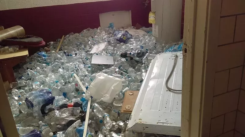 Bottled water covers the floor of a vacant school in Flint. - Facebook