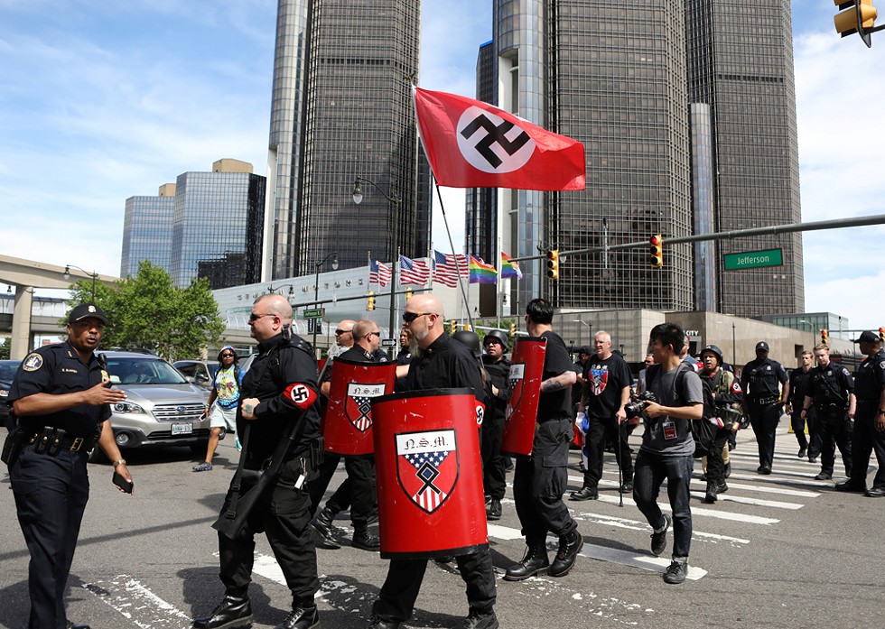 Emboldened by Trump? Members of the National Socialist Movement march with a Nazi swastika flag at Motor City Pride. - Jim Urquhart