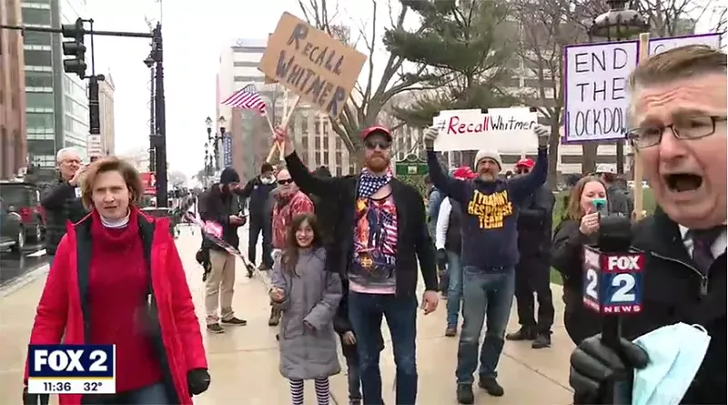 Royal Oak City Commissioner Kim Gibbs, in red, was spotted at Operation Gridlock. She could be seen repeatedly leaping out of the camera frame in a Fox 2 segment. - SCREENGRAB/ WJBK-FOX 2