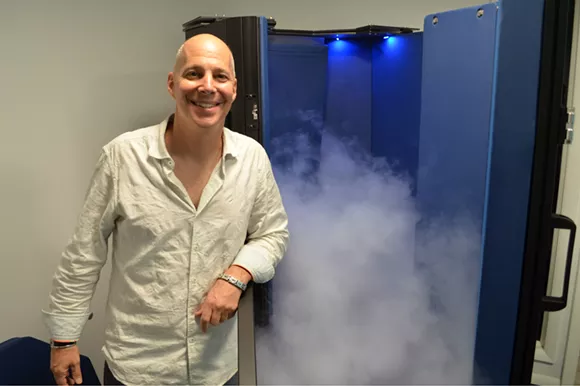 Eric Spector with the cryotherapy chamber at CryoWorks Michigan in Berkley. - Photo by Dustin Blitchok