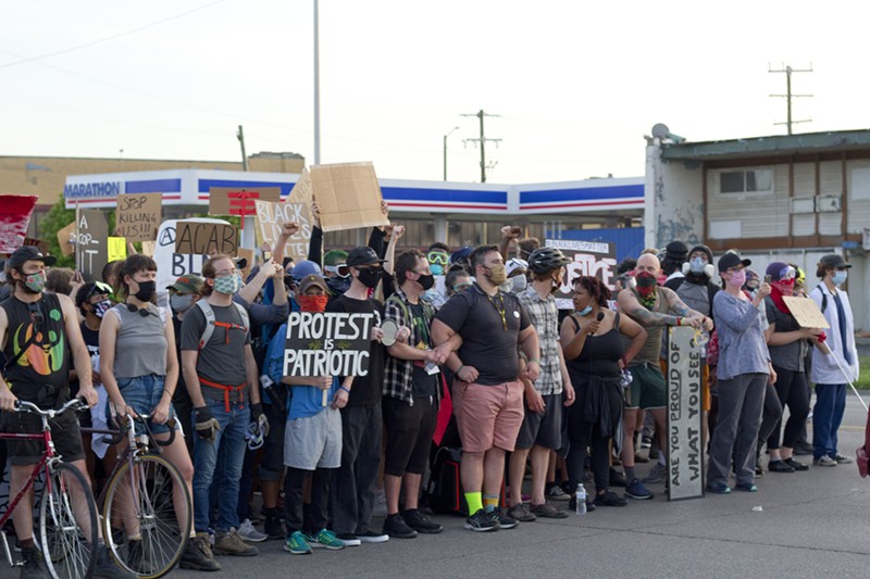Protesters locked arms as Detroit police in riot gear approached to enforce the curfew. - STEVE NEAVLING