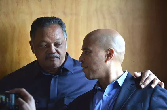 The Rev. Jesse Jackson and U.S. Sen. Cory Booker chat Thursday at Kuzzo's Chicken & Waffles in Detroit. - Photo by Dustin Blitchok