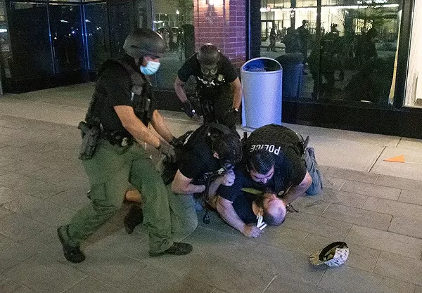 Detroit police tackle a protester early Sunday morning. - Adam J. Dewey