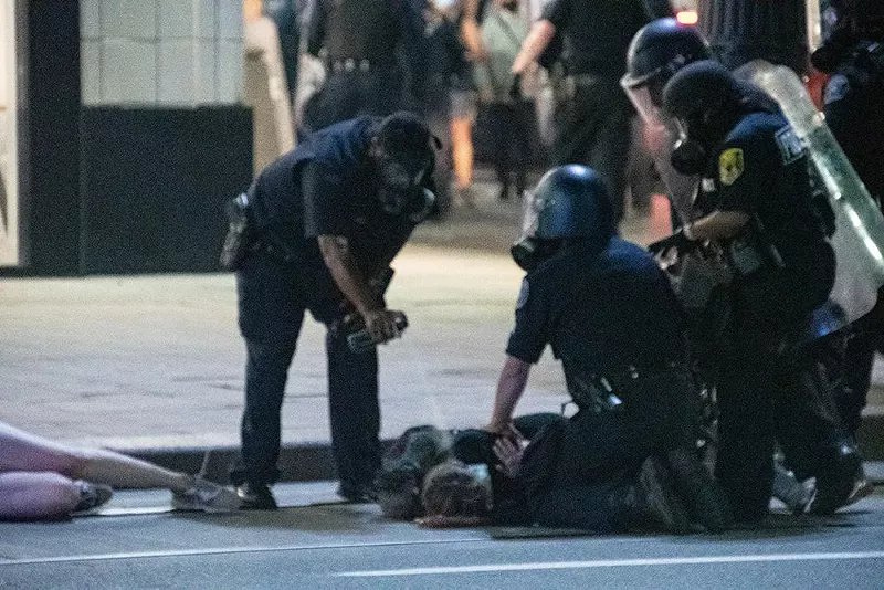 Police use pepper spray on a protester on Aug. 23. - Adam Dewey