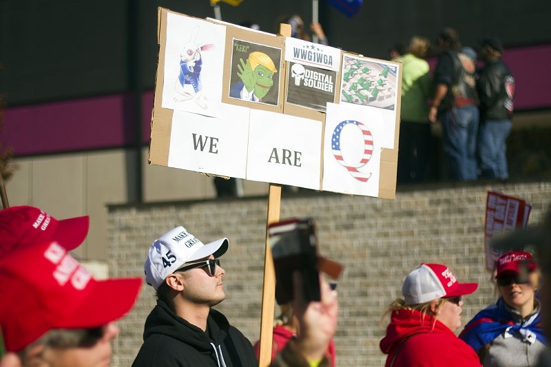 The disinformation age: A man holds a sign referencing the QAnon conspiracy theory at a rally for President Donald Trump in Detroit. - STEVE NEAVLING