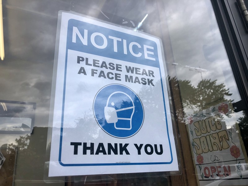 A sign at the Detroit Whole Foods asks customers to wear a face mask. - STEVE NEAVLING