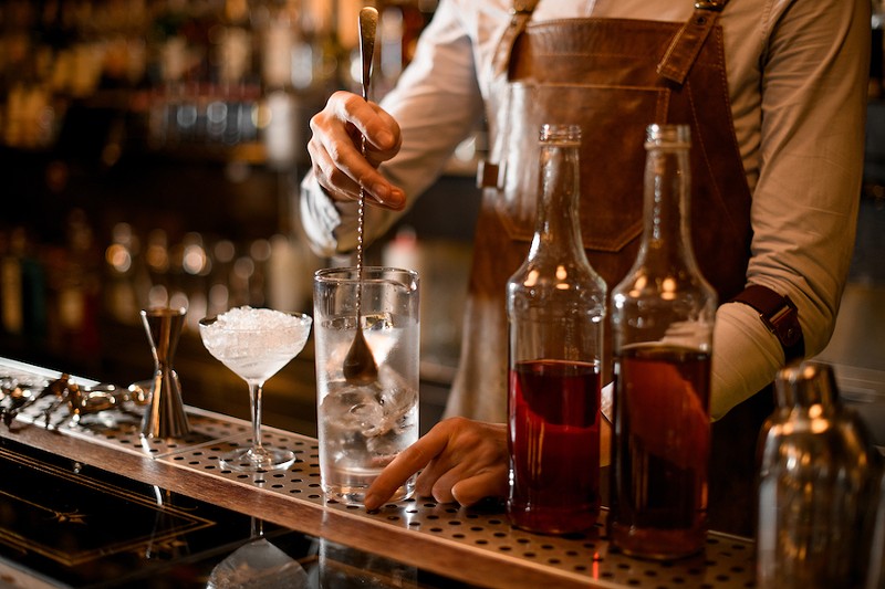 A bartender makes cocktails. - Shutterstock.com