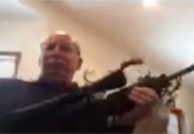 Screengrab of Traverse County Commissioner Vice Chair Ron Claus clutching a semiautomatic gun during a virtual meeting on Jan. 21. - TRAVERSE COUNTY