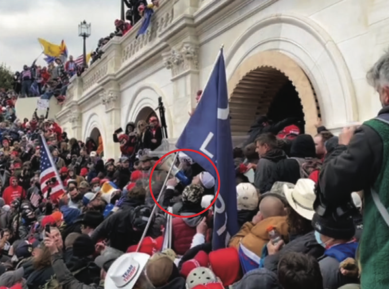 Trevor Brown is circled in red near the front of a violent crowd that was trying to push past police officers at a tunnel at the U.S. Capitol. - FBI