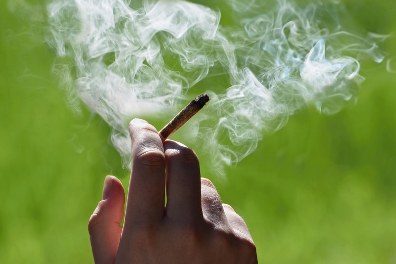 A person smoking a marijuana joint. - Shutterstock