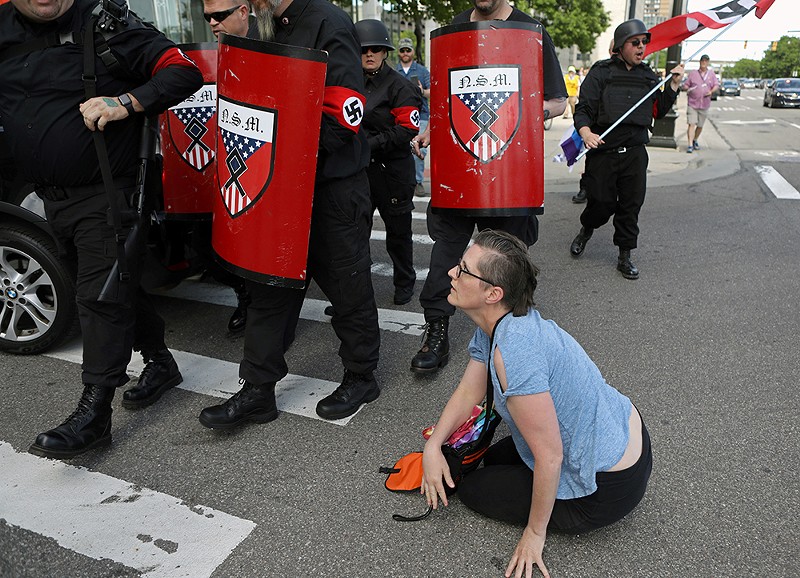 Jessica Prozinski sits on the ground after she was shoved by members of the National Socialist Movement during Motor City Pride in Detroit. - Jim Urquhart/Rueters