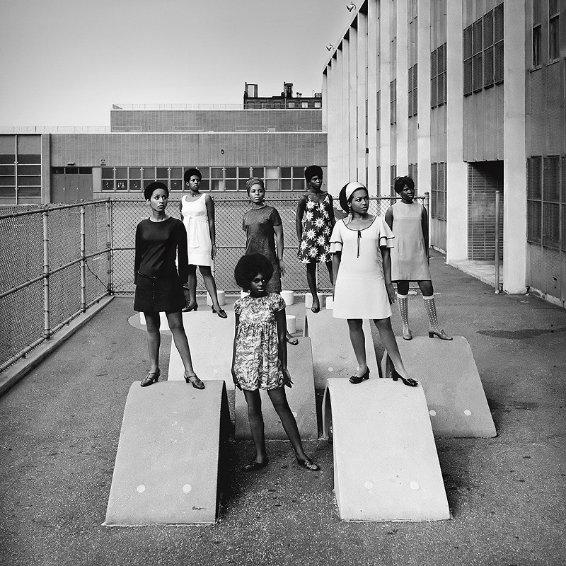 Kwame Brathwaite, Photo shoot at a public school for one of the AJASS-associated modeling groups that emulated the Grandassa Models and began to embrace natural hairstyles. Harlem, ca. 1966; from Kwame Brathwaite: Black Is Beautiful (Aperture, 2019). - COURTESY OF THE DIA