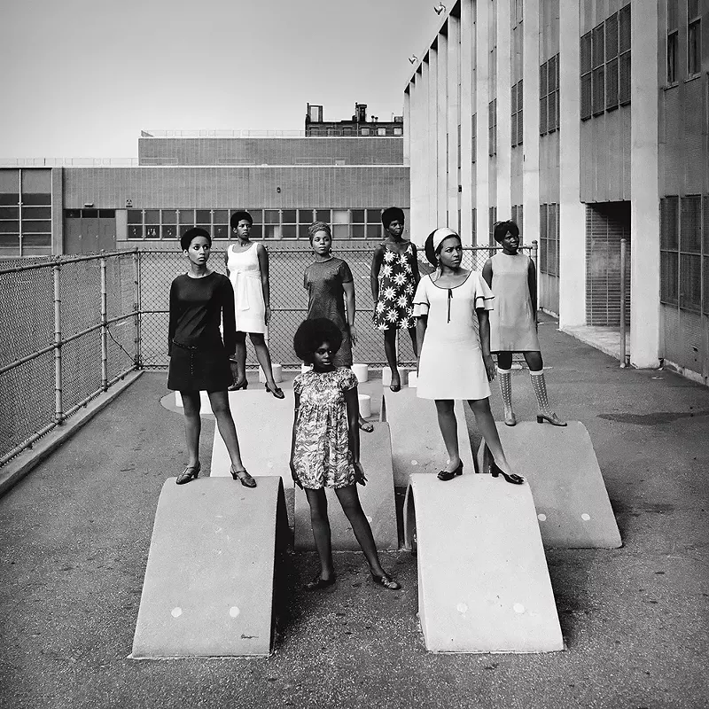 Kwame Brathwaite, Photo shoot at a public school for one of the AJASS-associated modeling groups that emulated the Grandassa Models and began to embrace natural hairstyles. Harlem, ca. 1966; from Kwame Brathwaite: Black Is Beautiful (Aperture, 2019). - Courtesy of the DIA