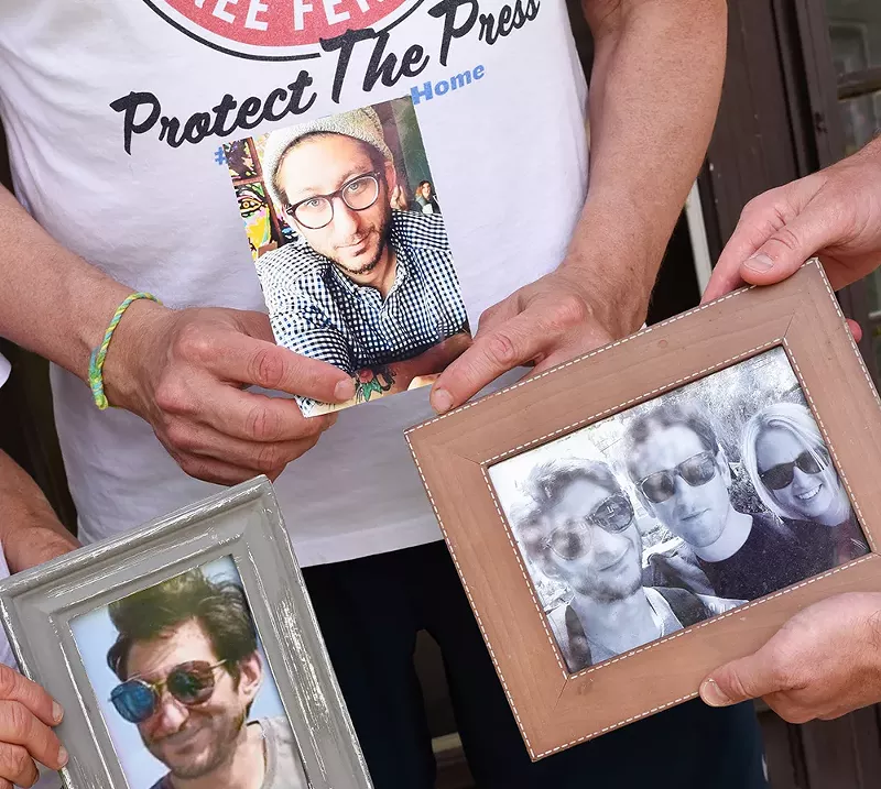 Journalist Danny Fenster's family holds photographs of him at their Huntington Woods home. - Kelley O'Neill