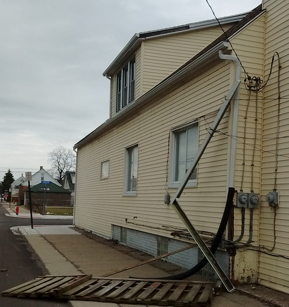 Wind caused gutter damage to this Hamtramck home, as well as taking out a few sections of fence. - Photo by Michael Jackman
