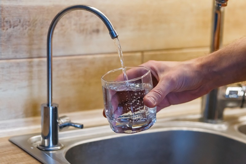 A glass filled with tap water. - Shutterstock.com