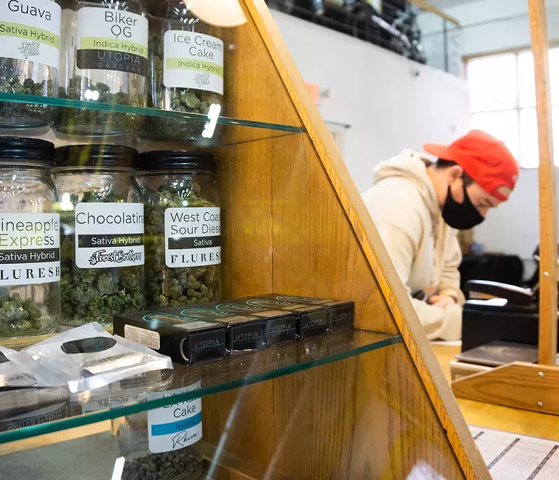 A cashier at a Detroit cannabis dispensary. - se7enfifteen