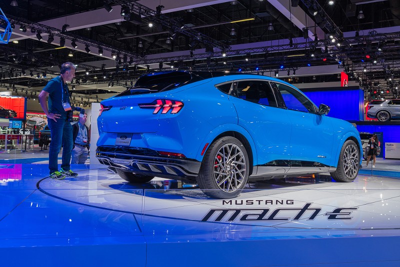 A man looks at a new all-electric Ford Mustang Mach-E model on display. - Shutterstock