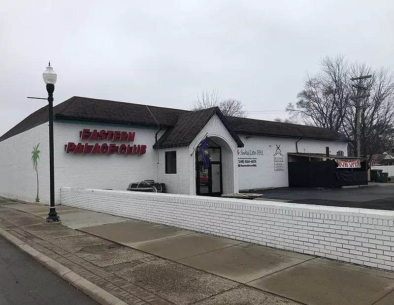 A palm tree and a mermaid have been painted on the sides of the building, and the finishing touches are being put on a sign made out of a surfboard. - Lee DeVito