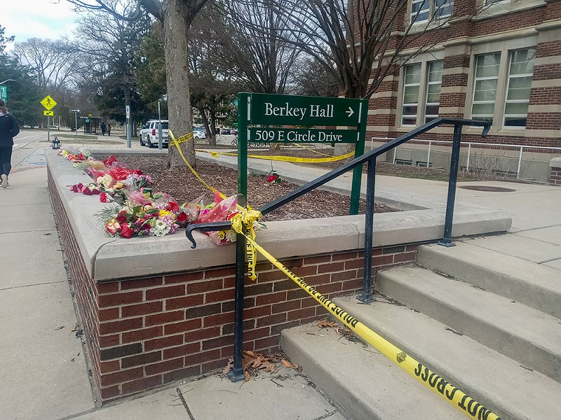 Bouquets of flowers are strewn across a ledge outside of Berkey Hall, where the shooting occurred. - Eleanore Catolico