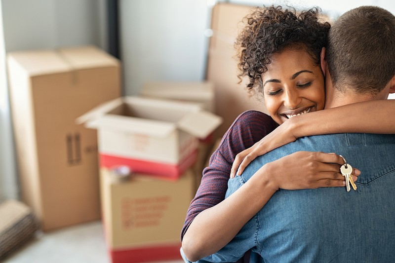 A photo showing a young couple moving in together. - Shutterstock