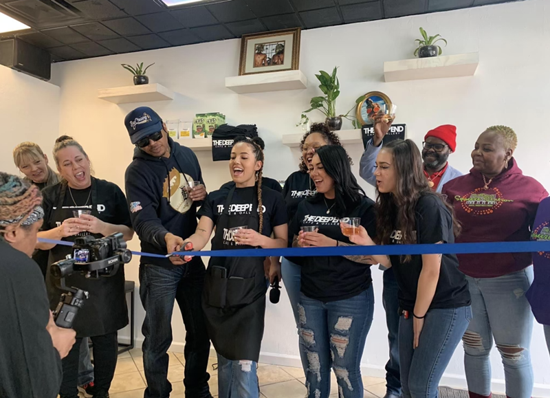 Owner Candace Cavazos, owners of The Squeeze Station, and other supporters cut the blue tape on The Deep End's opening day. - Courtesy of Candace Cavazos