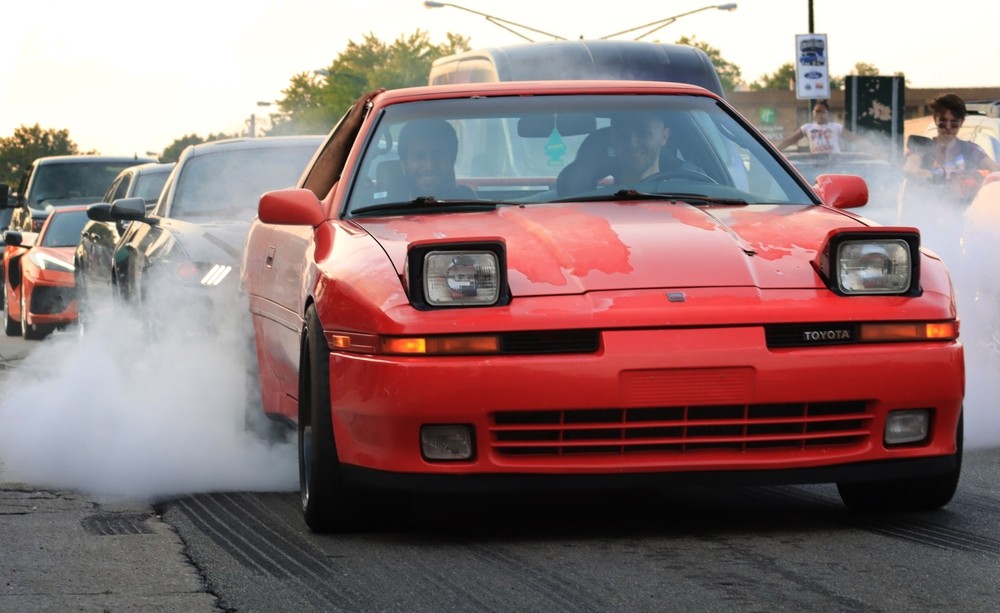 An old Toyota doing burnout at Woodward Dream Cruise. - Shutterstock