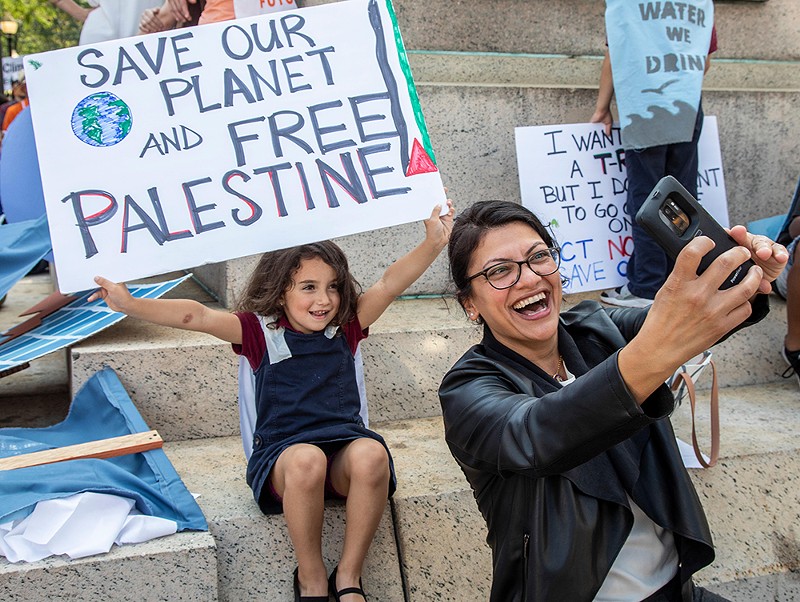 In a 2019 photo, Congresswoman Rashida Tlaib takes a selfie with a young girl holding a sign that says “Free Palestine.” - Jim West / Alamy Stock Photo